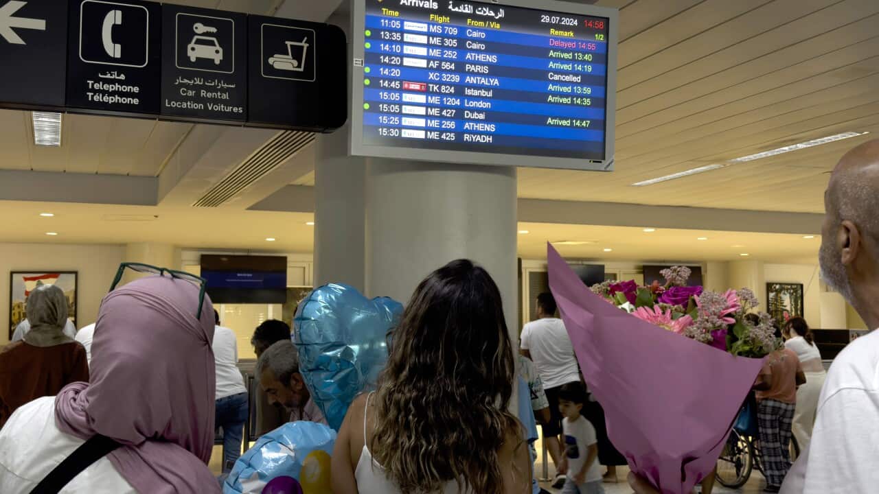 Passengers look at flight information boards at Rafik Hariri International Airport, in Beirut