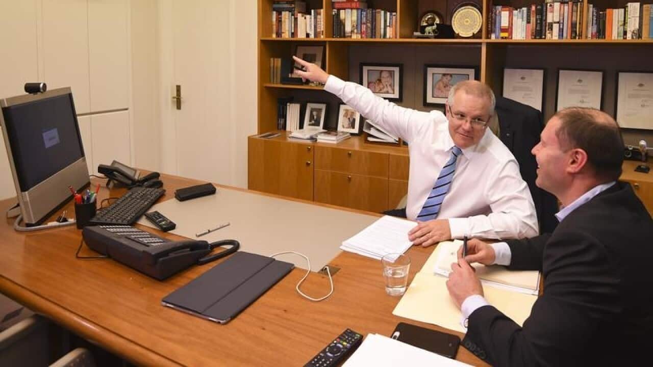 Scott Morrison and Josh Frydenberg at work in the office.