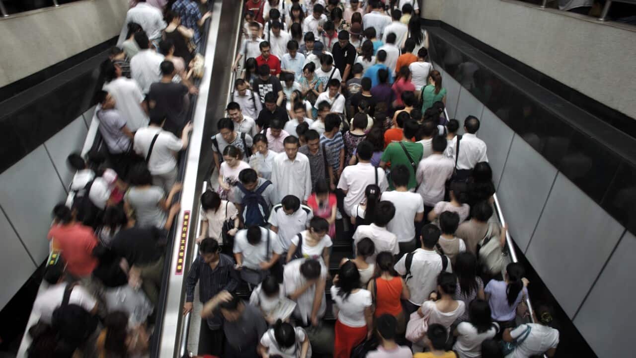 Morning commuters swarm through a major subway interchange station in downtown Shanghai, China.