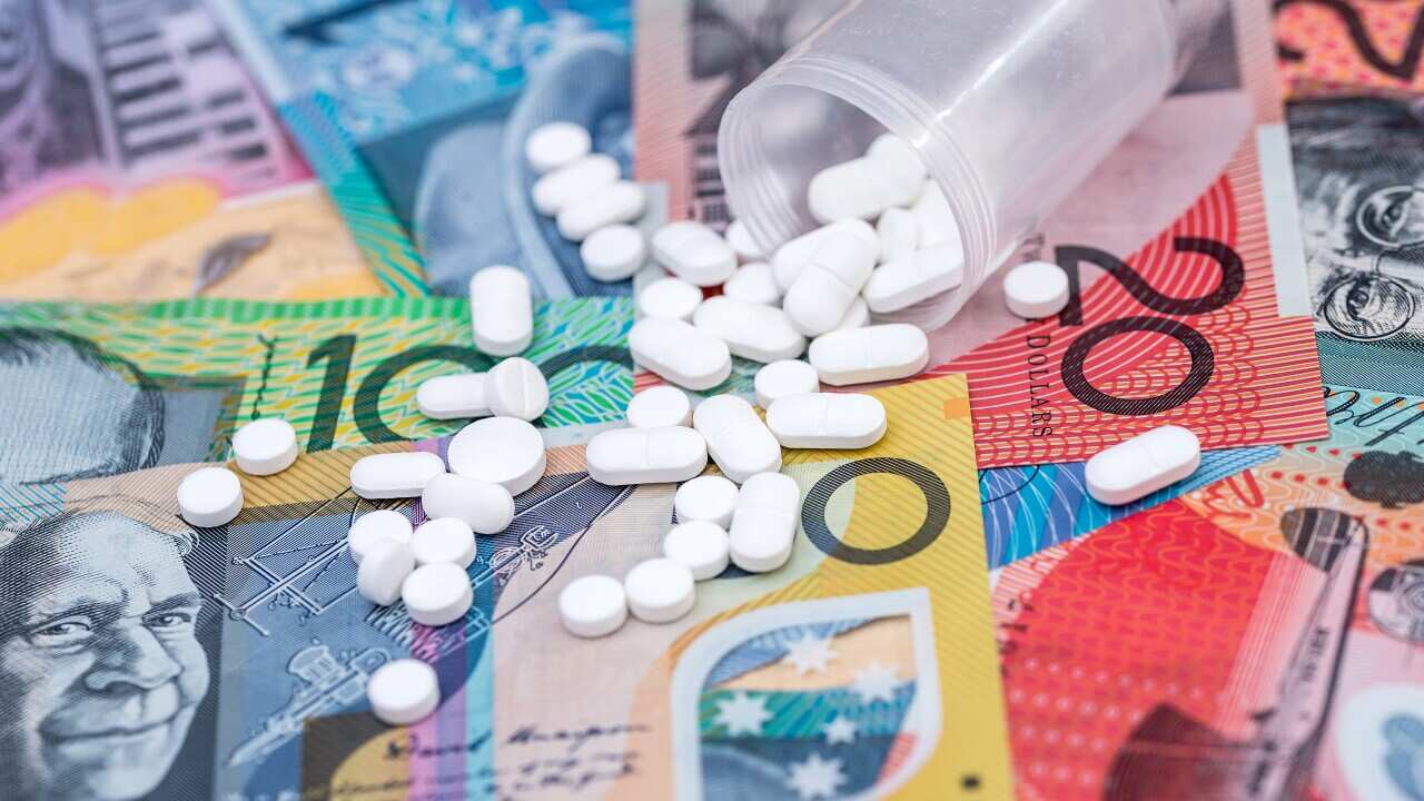 Dispersed white tablets on australian dollar banknotes