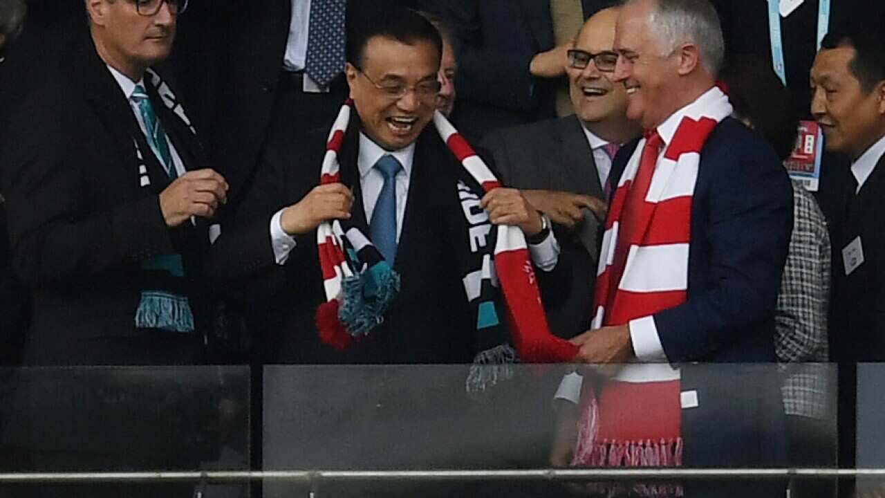 Chinese Premier Li Keqiang puts on a Swans scarf 