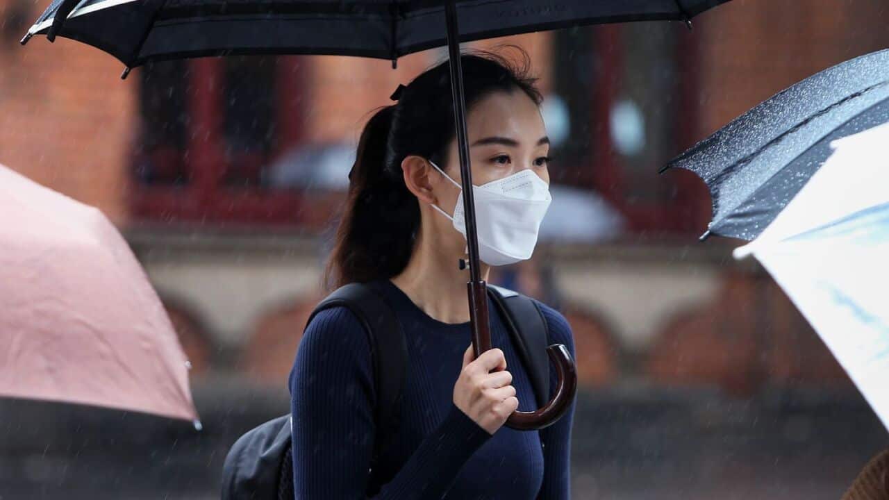 : A woman wears a face mask as she walks through the Chinatown district on March 04, 2020 in Sydney, Australia.