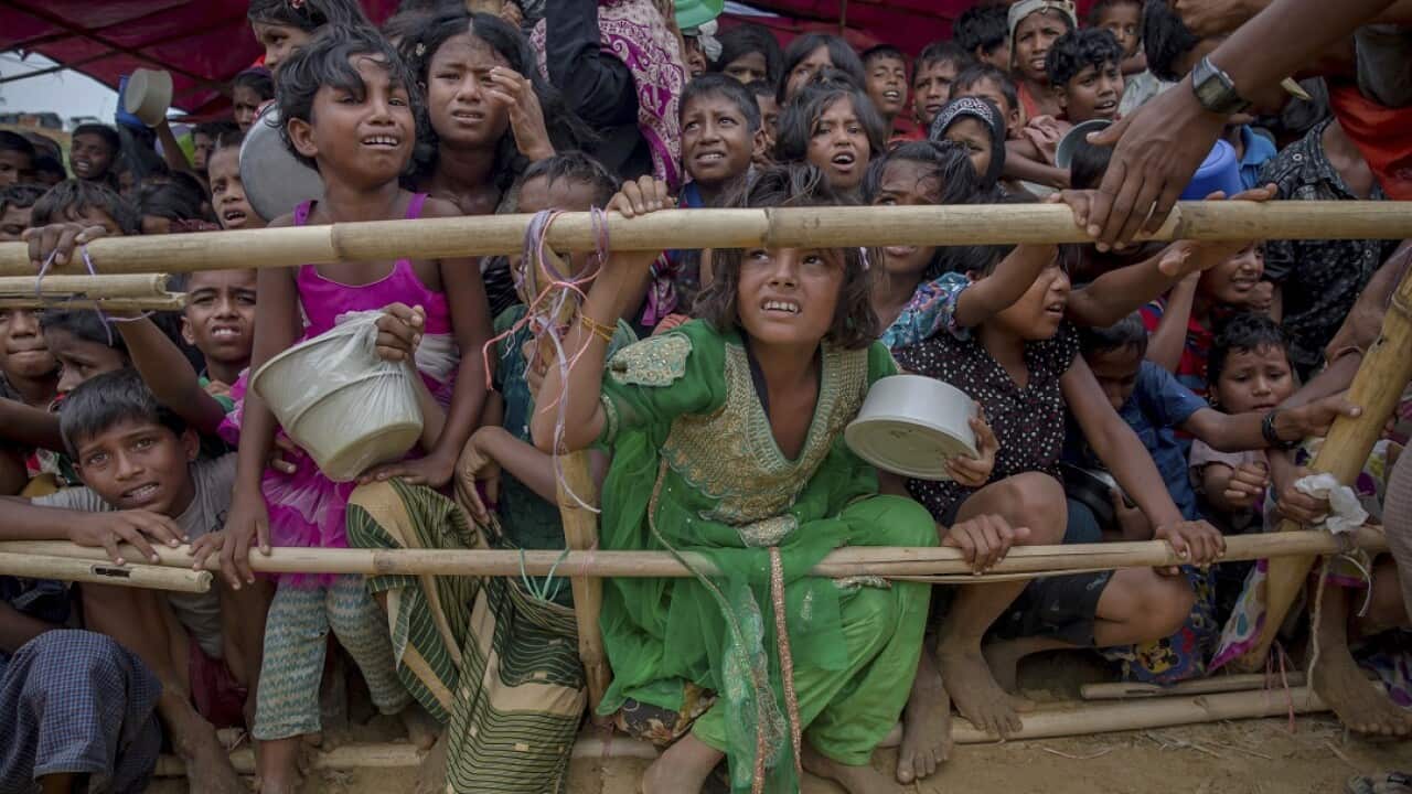 Rohingya children in Bangladesh wait for their turn to collect meals.