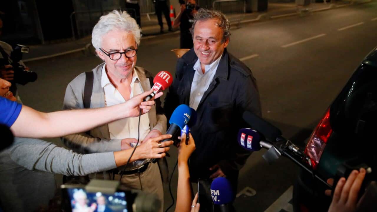 Michel Platini, right, and his lawyer William Bourdon answer reporters after Platini has been freed