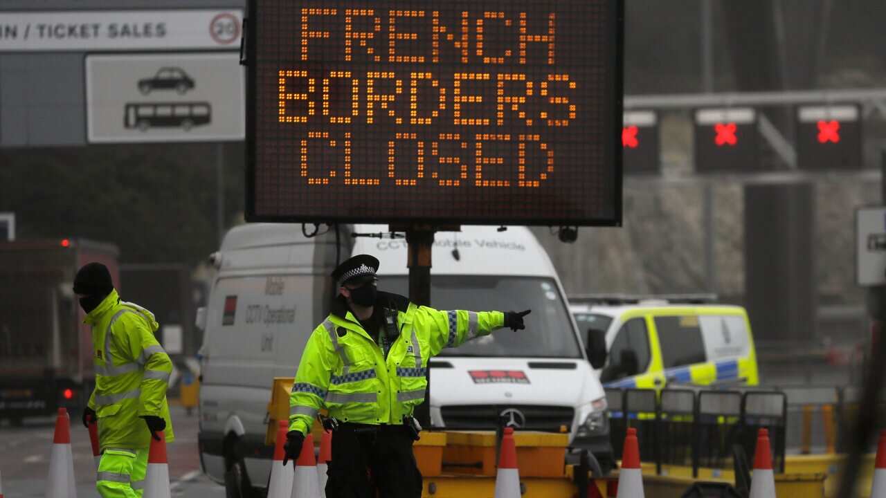 A police officer directs traffic at the entrance to the closed ferry terminal in Dover, England.
