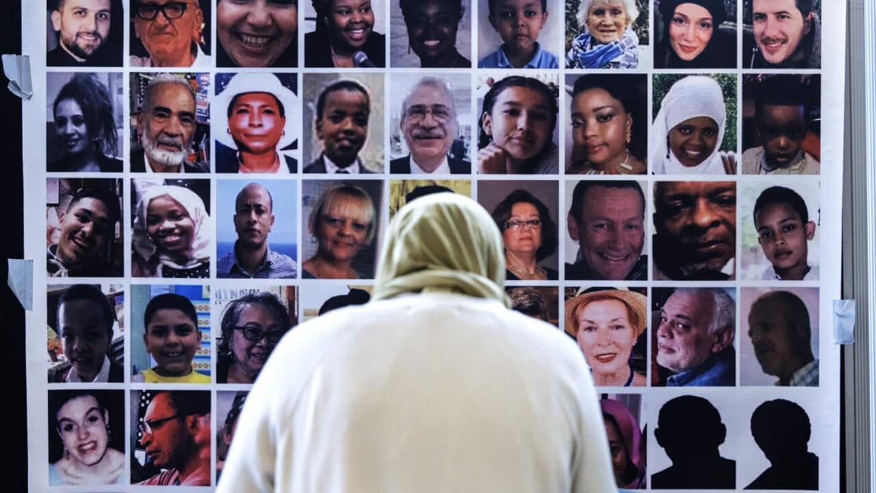A person looks at photos of victims of the Grenfell Tower tragedy in London.
