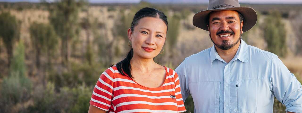 Poh Ling Yeow and Adam Liaw stand with Uluru in the background for their show Adam and Poh's Great Australian Bites.jpg