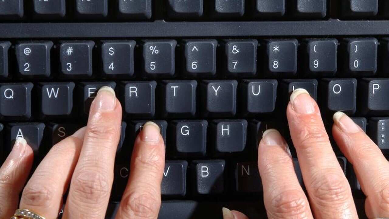Two hands typing on a computer keyboard