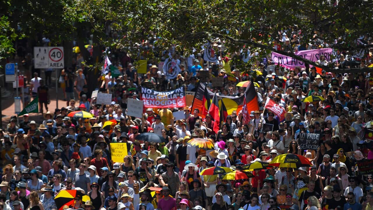 Protestors march down Pitt Street during an Invasion Day rally in Sydney, Sunday, January 26, 2020. (AAP Image/Paul Braven) NO ARCHIVING