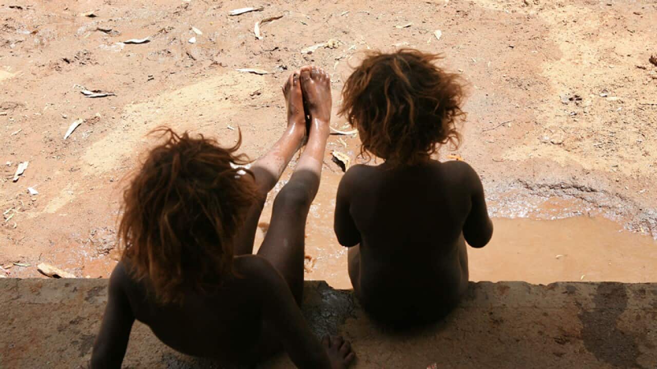An undated file image of sisters playing in the mud