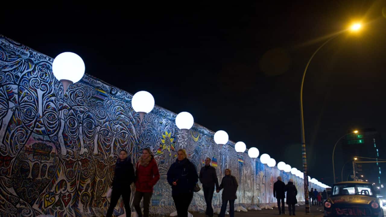 People pass by balloons of the art project 'Lichtgrenze 2014.