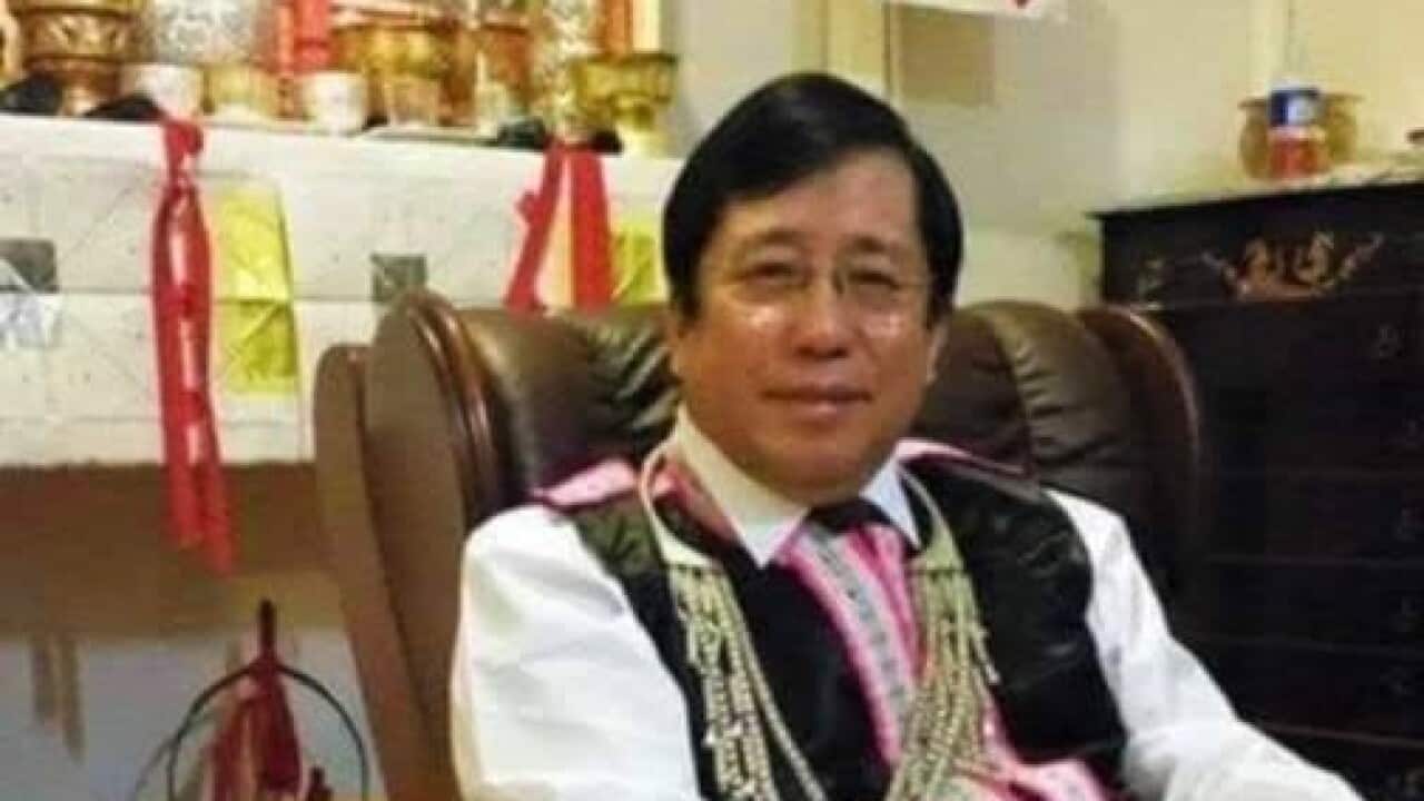 Dr Txawjpov Xaivkaub Thoj zaum ua ntej ntawm nws lub thaj neeb hnav tsoos Hmoob (Dr Pao Saykao).jpg