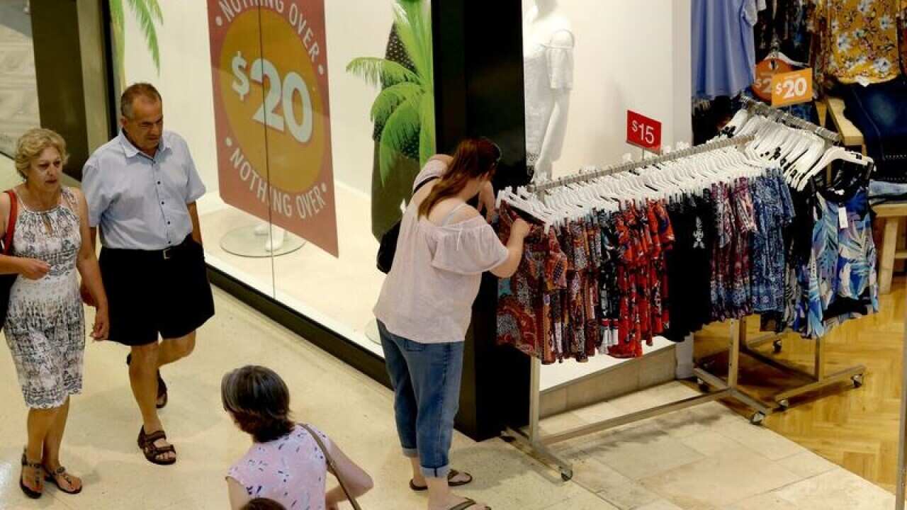 People walking past shops at a mall.