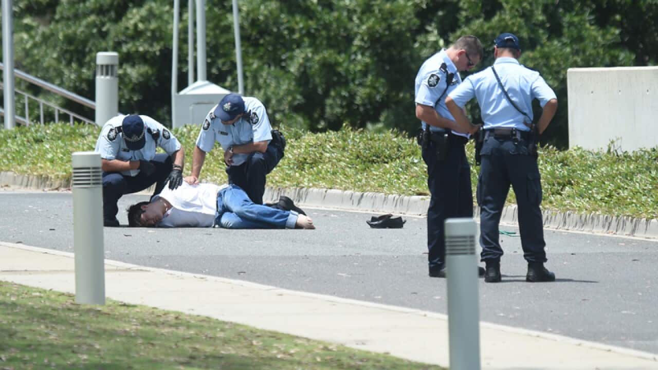 A man is detained by federal police outside Parliament House
