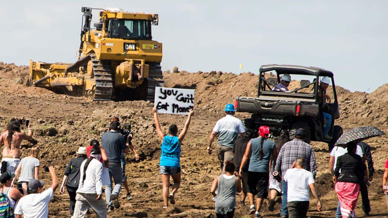 Native American protestors and their supporters are confronted by security during a demonstration against work being done for the Dakota Access Pipeline.