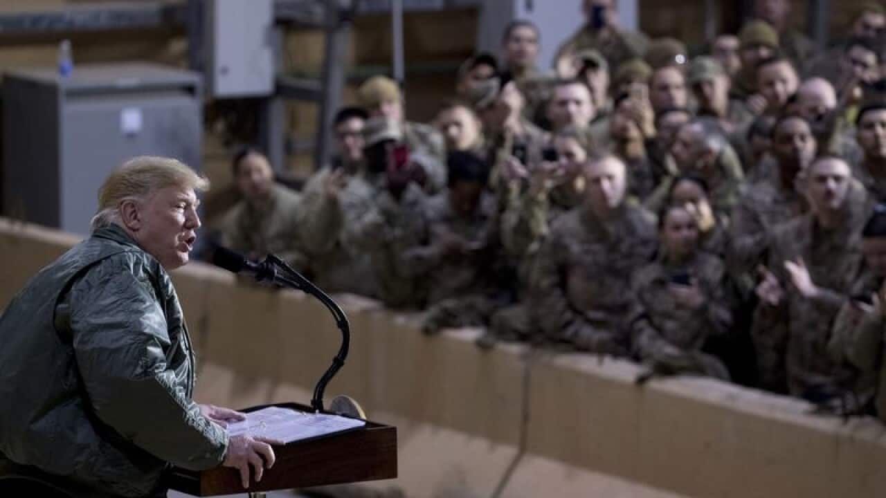 US President Donald Trump addresses troops in a hanger at Al Asad Air Base, Iraq.