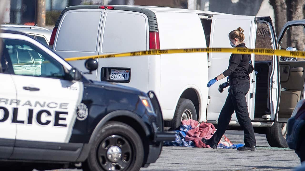 A police officer walking past a van that has its door open.