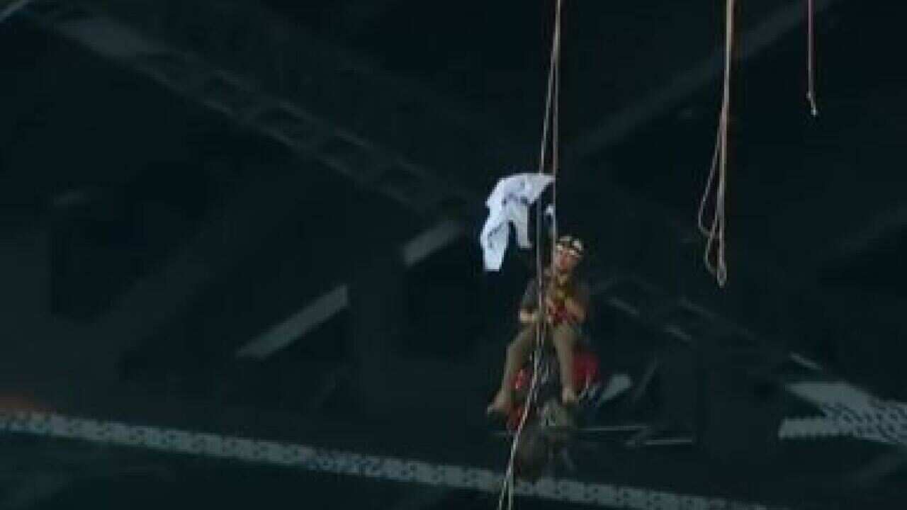 A Greenpeace protester tries to roll out his sign as he hangs from the bridge.
