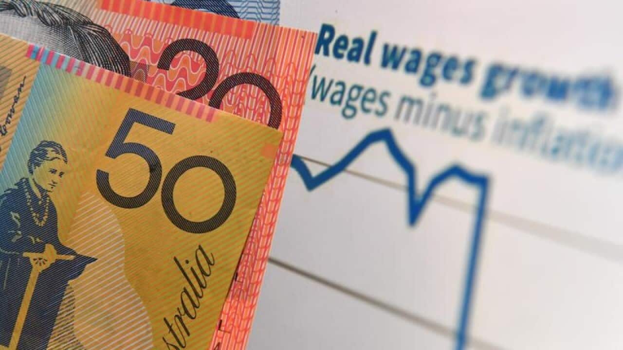 This is a file image of Australian money in front of a wages graph.