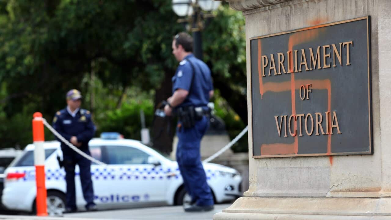 Police inspect graffiti on the front of the Victorian State Parliament, in 2012