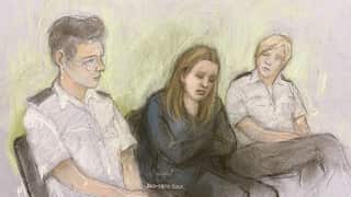 A court drawing of Lucy Letby sitting between two police officers.