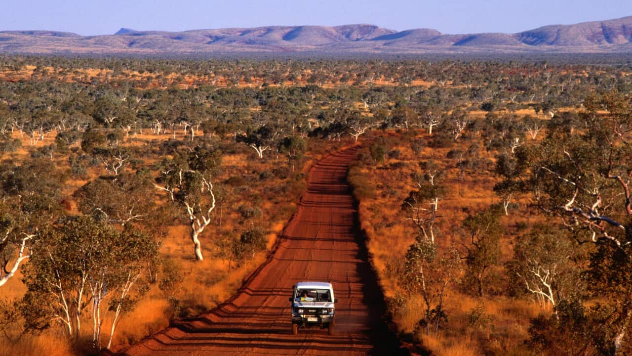 Car on outback road, Karijini National Park, Australia