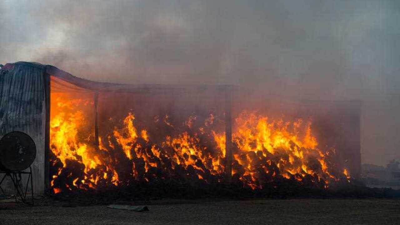 A hay shed burns on a property near Freeling in the mid-north of South Australia, Wednesday Nov. 25, 2015. Two people have been confirmed killed, with fears held for a third, in a bushfire burning out of control north of Adelaide. (AAP Image/Brenton Edwar