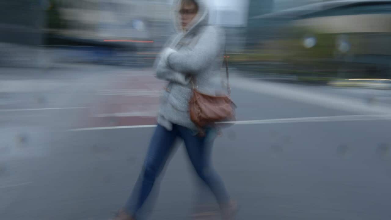 A woman rugs up as she walks in Melbourne