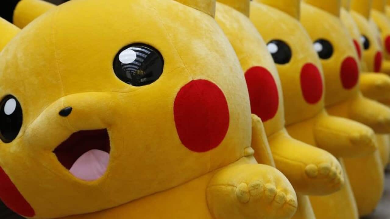 Dozens of Pokemon character Pikachu parade at a shopping centre