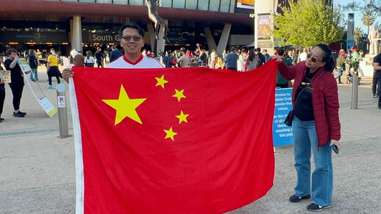 Chinese soccer fans with flag before world cup qualifier.jpg