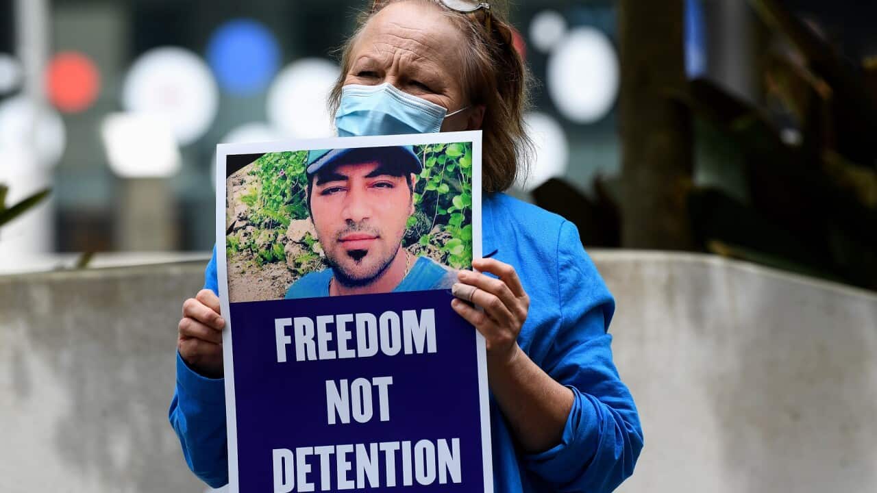 A supporter holds a placard following the Omid Masoumali Inquest findings