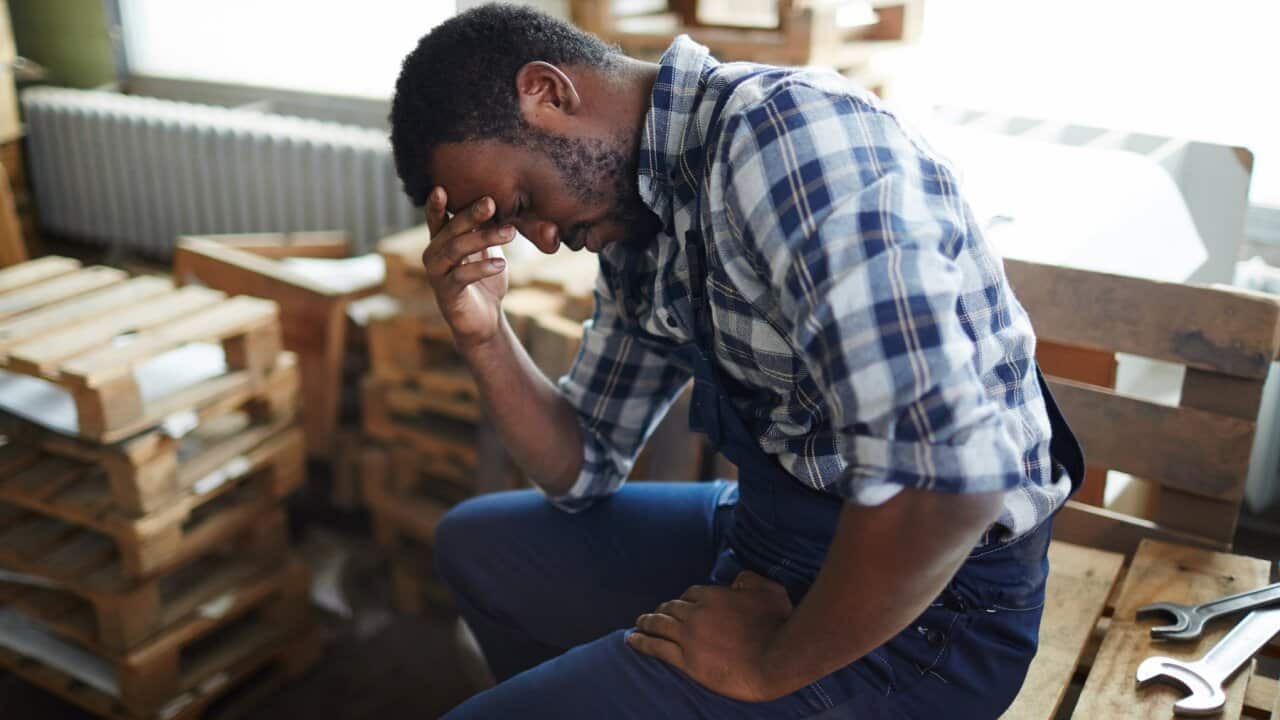 Exhausted African employee in warehouse