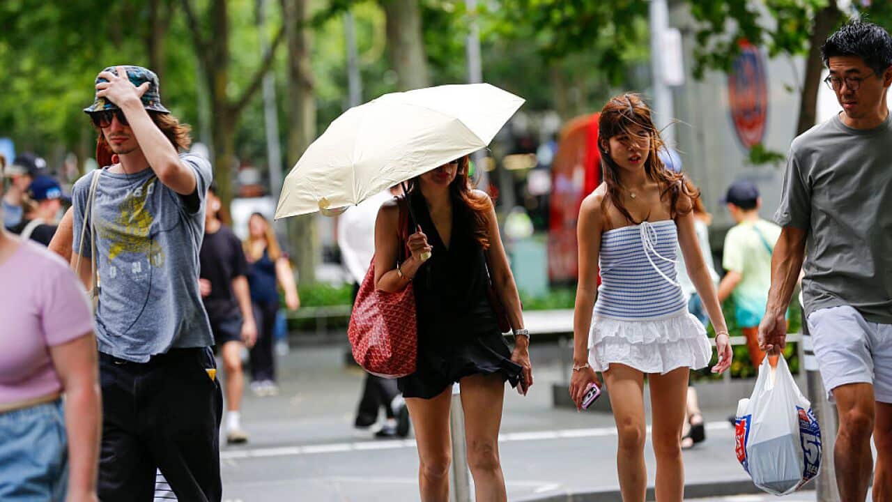 A woman with an umbrella moves through the city amid extreme