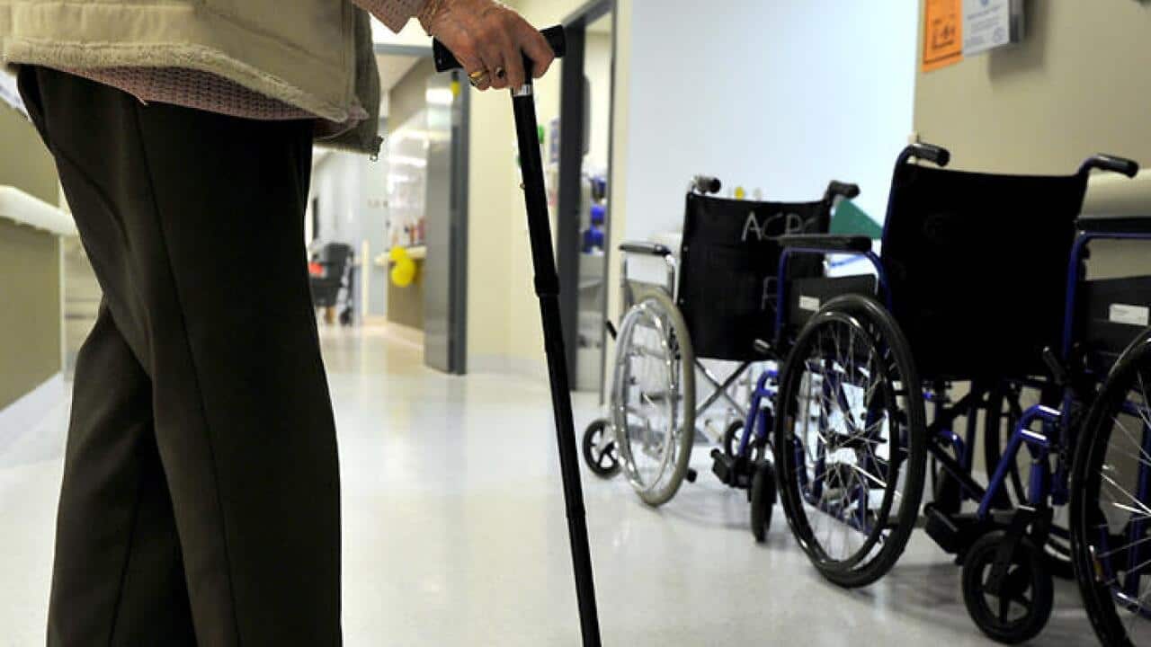 A woman uses a walking stick to assist her mobility in Canberra, Friday, May 24, 2013. (AAP Image/Alan Porritt) NO ARCHIVING