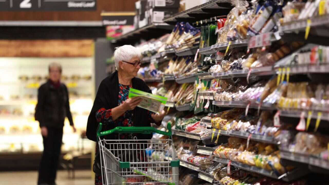 An older women shopping in the bread aisle at Woolworths