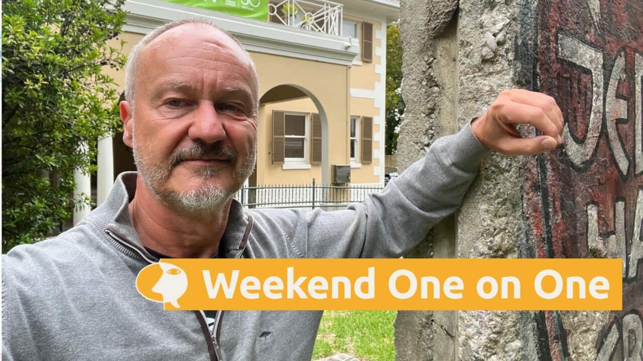 Christoph Mücher stands next to a remnant of the Berlin Wall that is part of a permanent display at the Goethe-Institut in Sydney (Supplied-Christoph Mücher).jpg