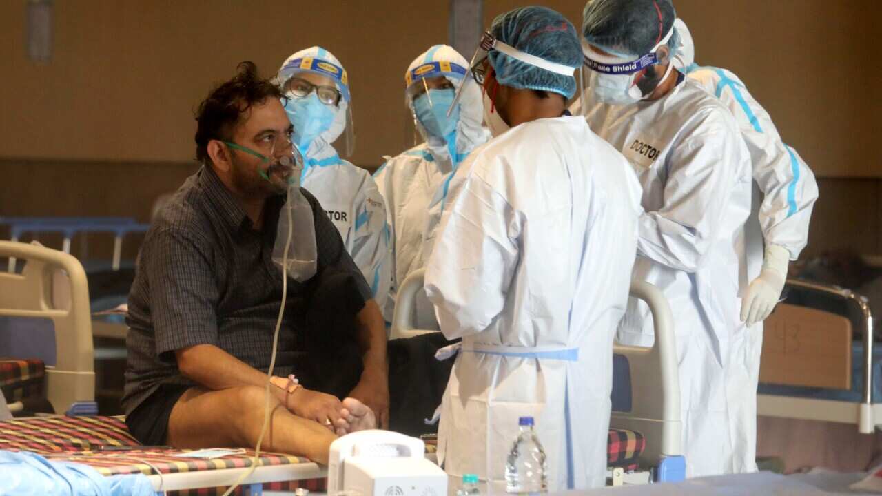 Doctors attend to a patient inside the Shehnai Banquet Hall, a temporary care centre for Covid-19