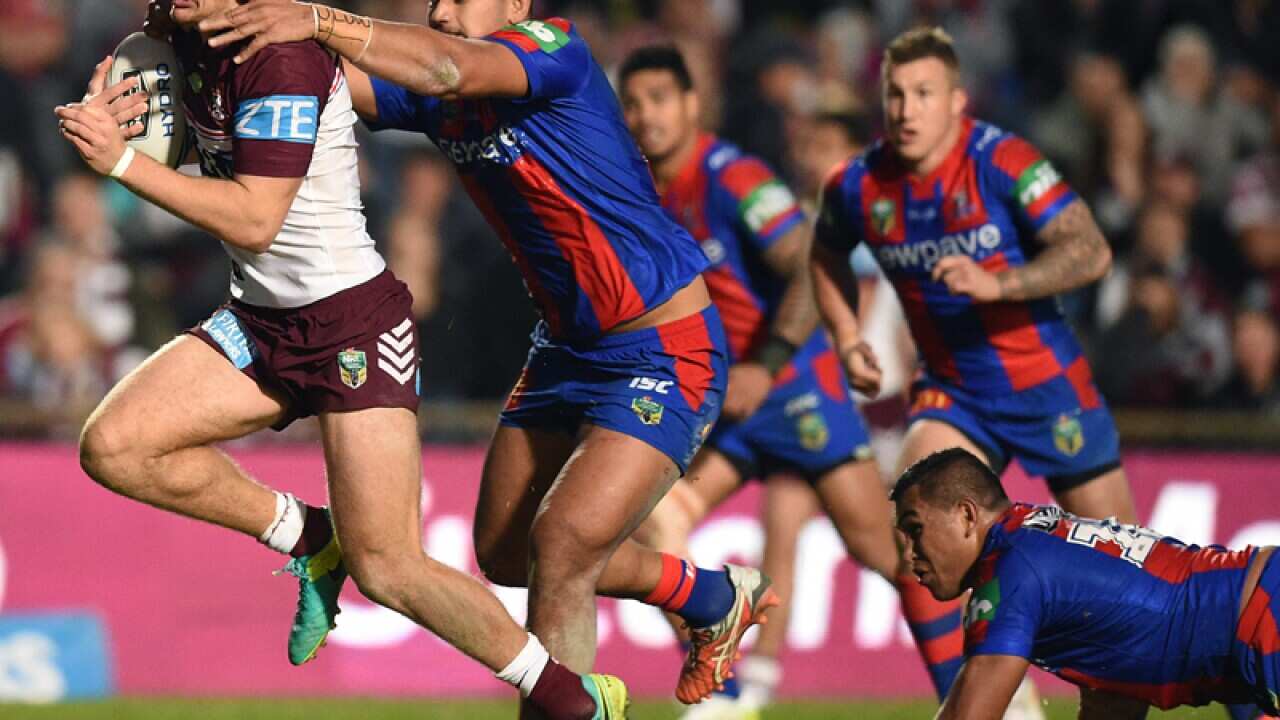 Tom Trbojevic of the Sea Eagles is tackled by Pauli Pauli