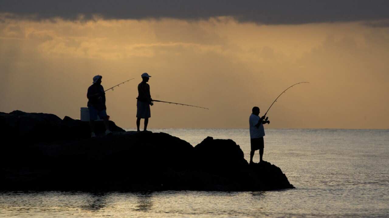 Fisherman cast their lines off a jetty in the early morning hours