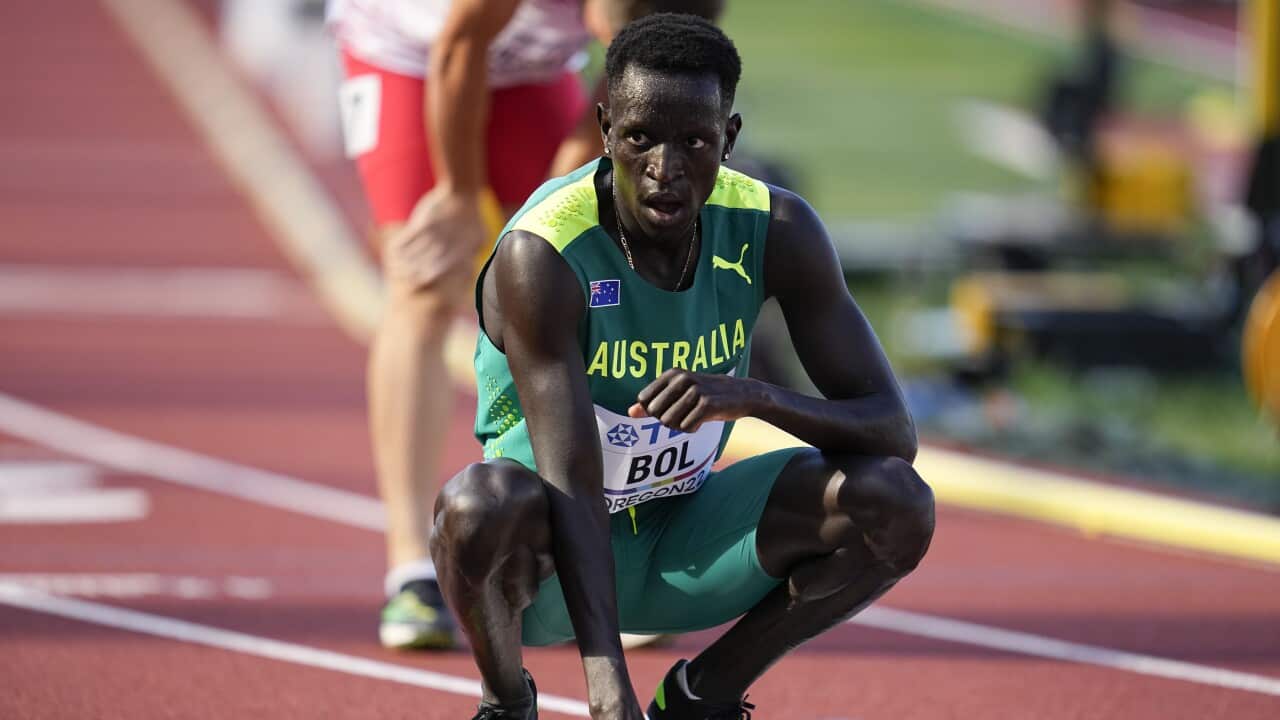 Peter Bol crouching down on a running track.