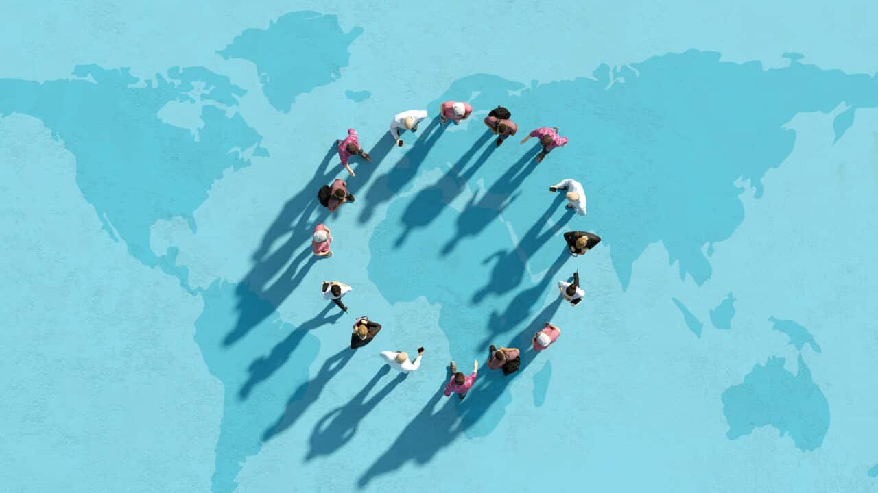 A graphic showing people standing in a circling and their shadows cast on the ground which shows a map of the earth.