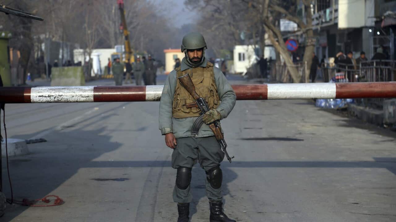 An Afghan security forces stand the aftermath of Saturday's suicide attack in Kabul.