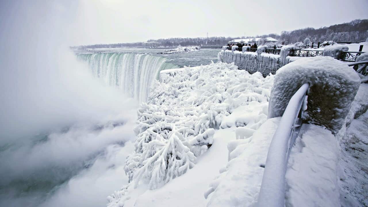 Visitors take photographs at the brink of the Horseshoe Falls in Niagara Falls.