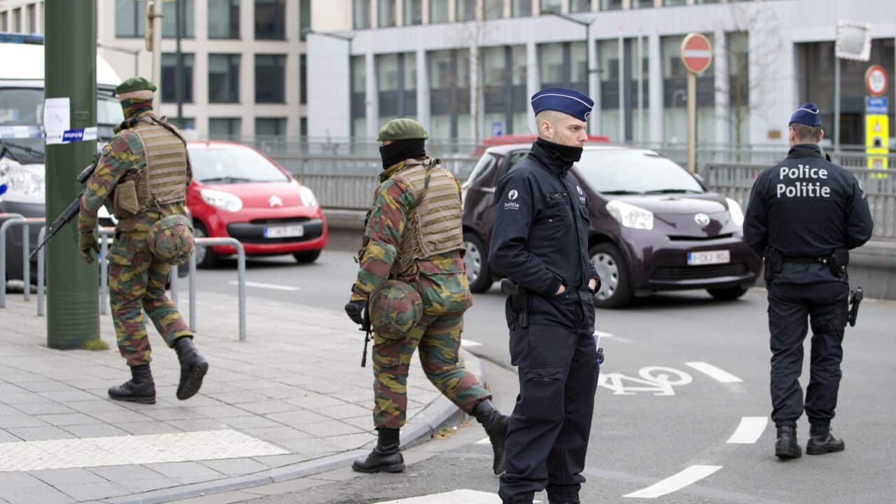 Police and Belgian Army soldiers patrol outside the federal court building in Brussels on Thursday, April 14, 2016.