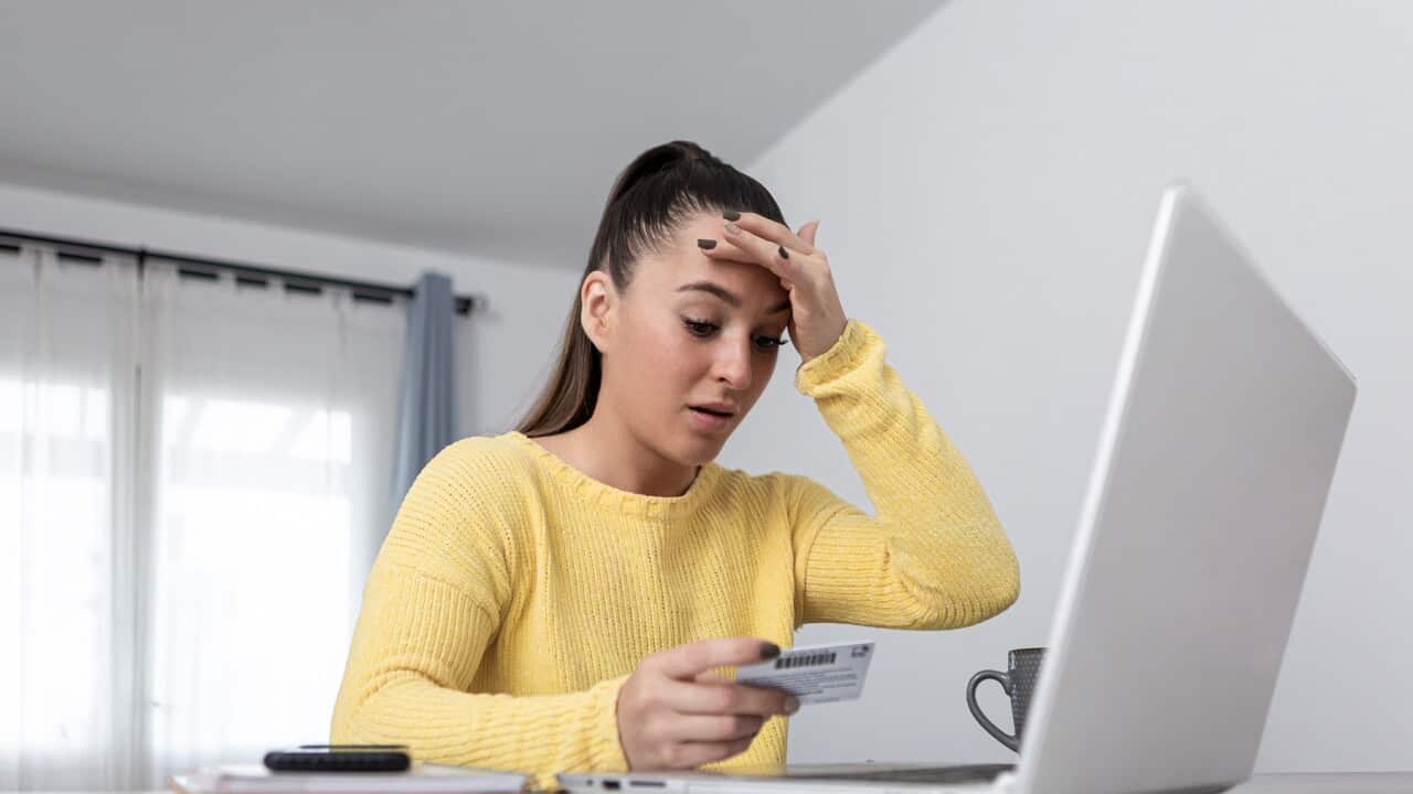 Anxious woman with credit card shopping online