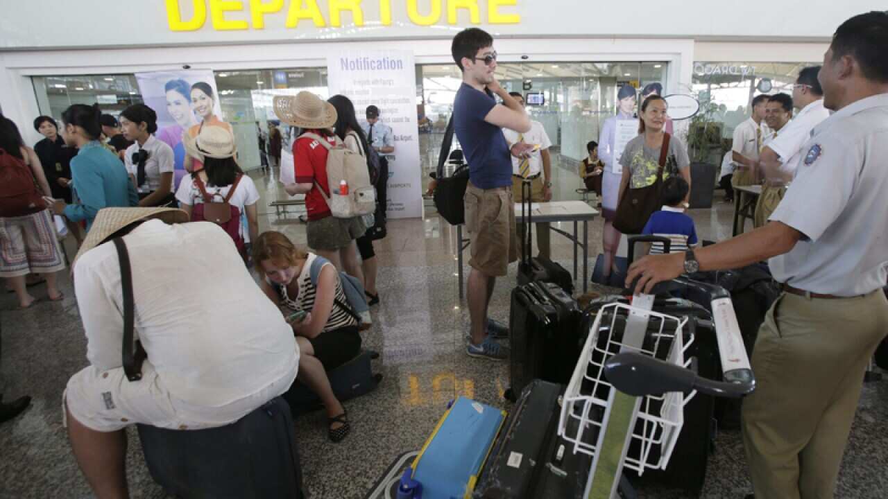 Pas sangers wait for information on their delayed flights in Bali.
