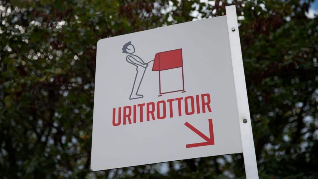 A picture shows a sign indicating a 'uritrottoir' public urinal on August 13, 2018, on the banks of the river Seine in Paris.