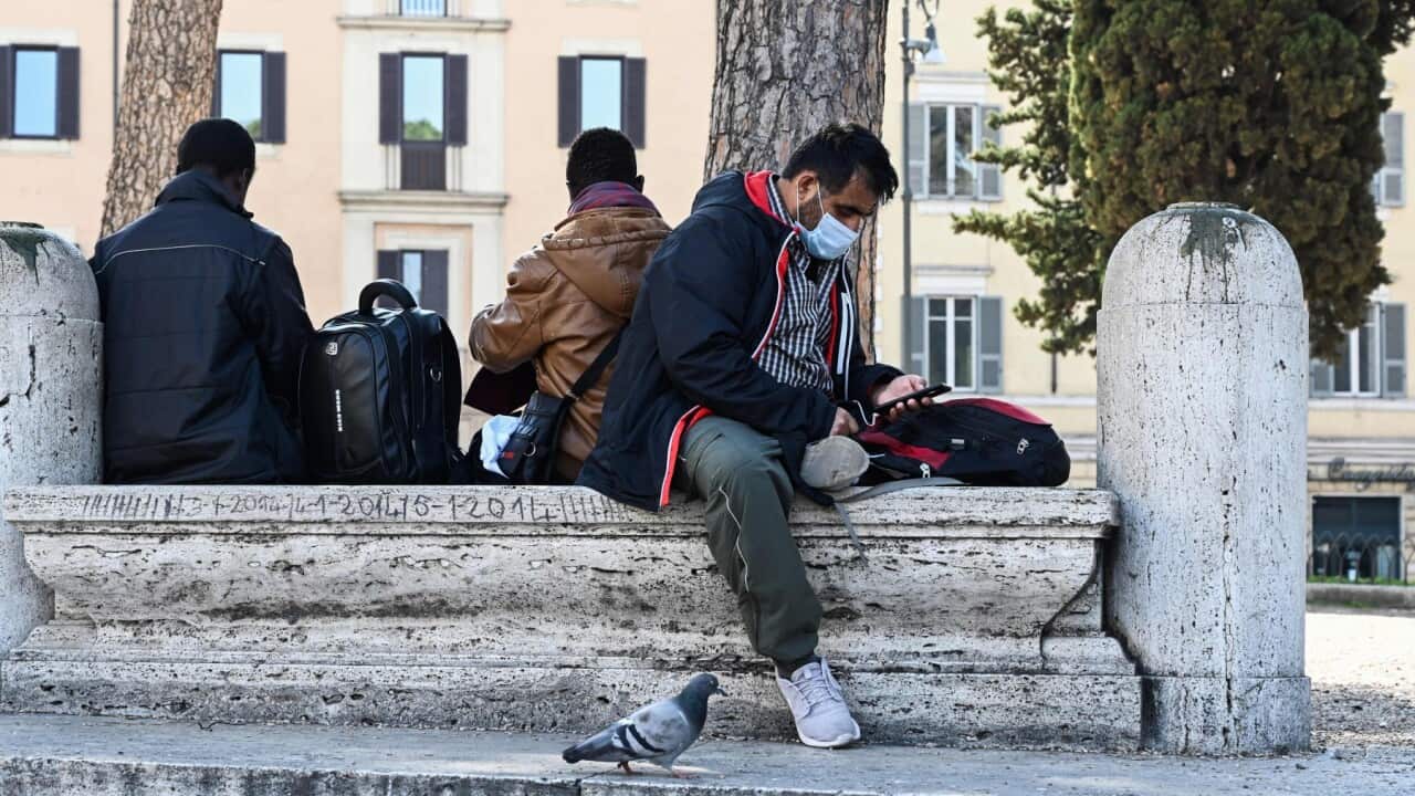 Migrants sit on Piazza dell'Aracoeli in central Rome on March 19, 2020, during the country's lockdown aimed at stopping the spread of the COVID-19 (new coronavirus) pandemic