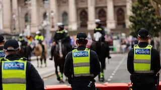Rear view of police wearing yellow vests in a street