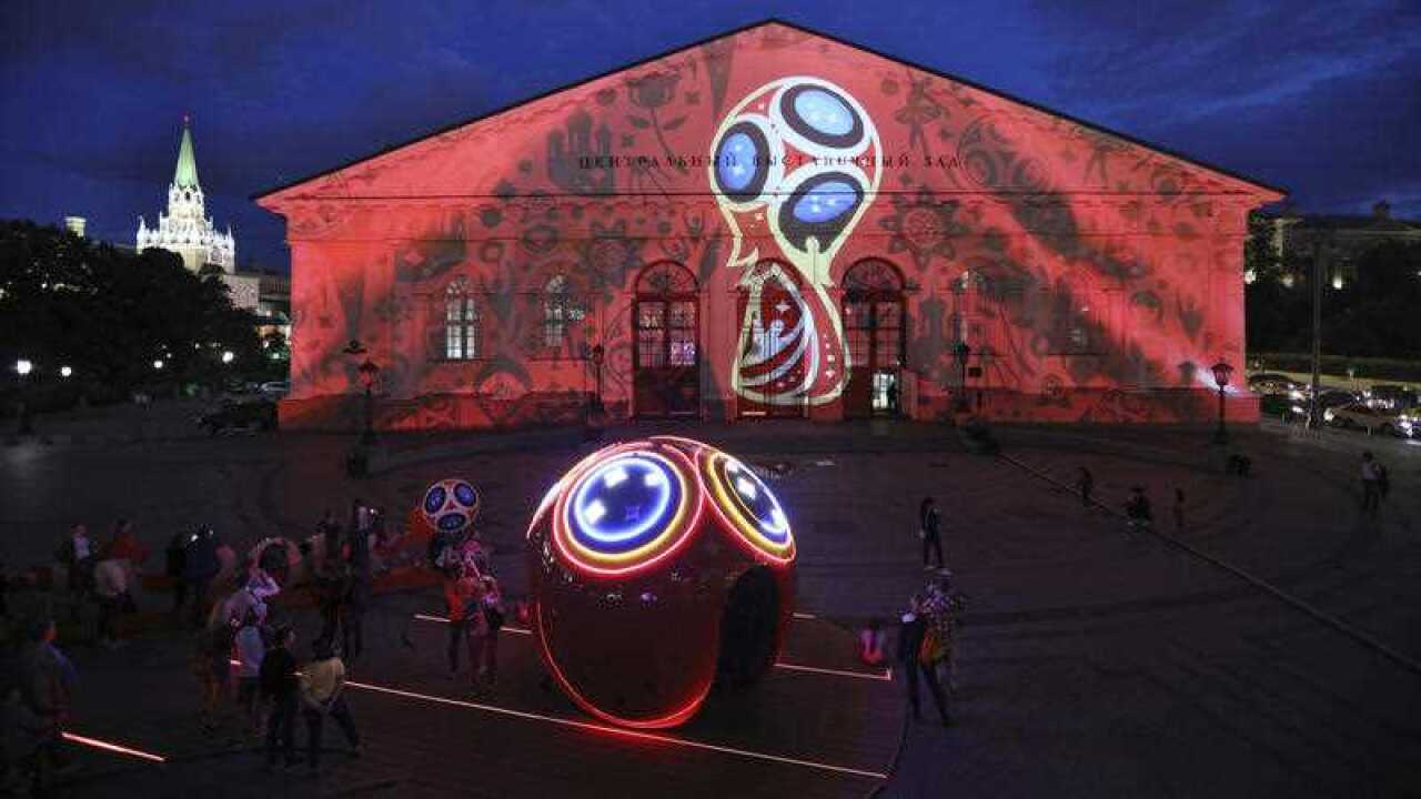 People enjoy watching a projection mapping on the Moscow Manege at Manege Square in Moscow on June 3, 2018.